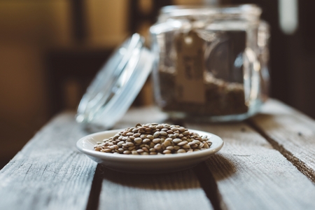 Glass jar with green lentil on rustic wooden backgroundの写真素材