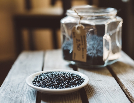 Glass jar with black lentil on rustic wooden backgroundの写真素材