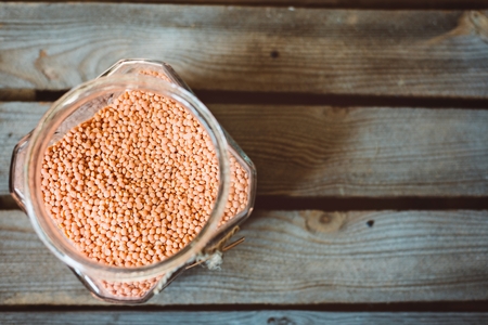 Glass jar with reg orange lentil on rustic wooden backgroundの写真素材