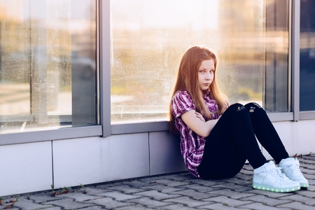 Offended ten years old blue eyed girl at the city. Summertimeの写真素材