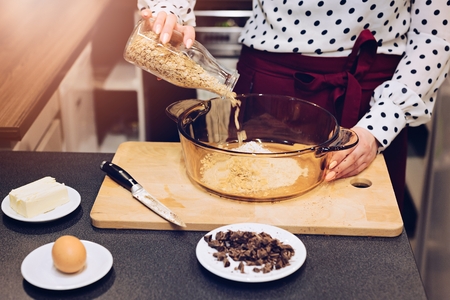 Woman prepares delicious, healthy cookies from spelt flour, oatmeal and chocolate
