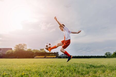 8 years old boy child playing football on playing field. Child playing footballの写真素材