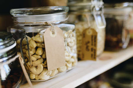 Cashew nuts in glass jar on shelf in a shop with eco foodの写真素材