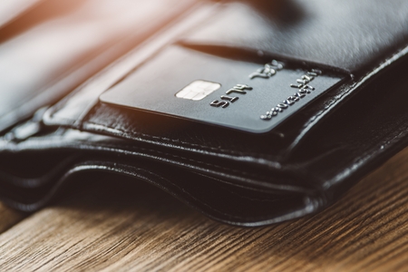 Plastic credit card in leather wallet on wooden background.の写真素材
