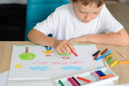 Child drawing a card for daddy for father's dayの写真素材