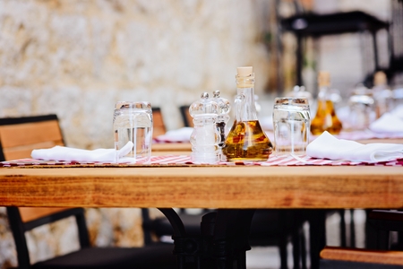 Outdoor restaurant table with olive bottle and spicesの写真素材