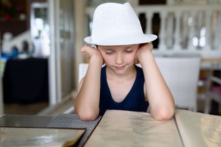 Boy reading menu in restaurant or cafe. Child in restaurantの写真素材