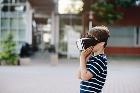 Little child boy watching simulation in virtual reality googles.の写真素材