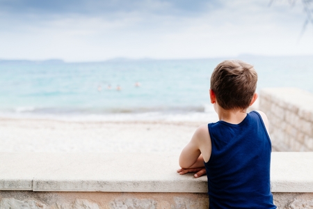 Thoughtful little boy on summer vacations at the seaの写真素材