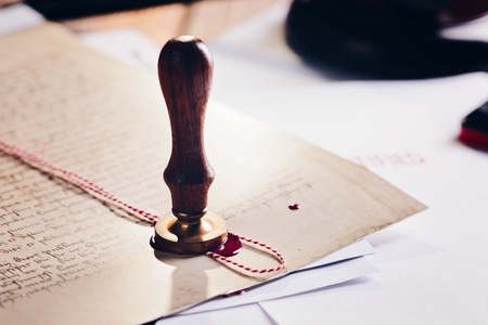 Metal notary public wax stamper on old document. Law office.の写真素材