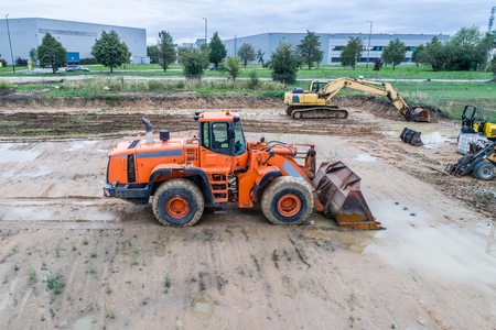Orange loader bulldozer in the mud on construction siteの写真素材