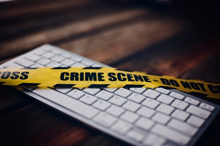 Yellow crime scene tape on computer keyboard. Computer crime concept.の写真素材