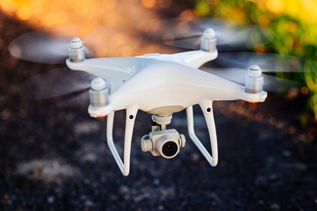 White drone quadcopter with camera in flightの写真素材