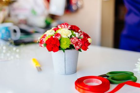 Red carnations and gerbera daisies. Beautiful flower composition in small flower potの写真素材