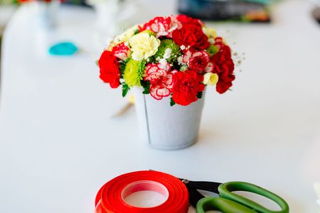 Red carnations and gerbera daisies. Beautiful flower composition in small flower potの写真素材