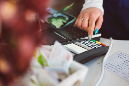 Owner of florist shop entering the amount to be paid at the credit card terminalの写真素材