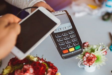 Customer paying contactless with phone in florist shopの写真素材