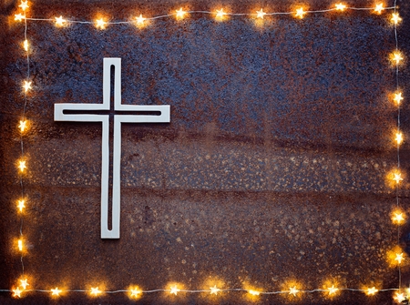 Wooden crucifix on rusty iron background with lightsの写真素材