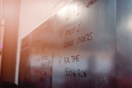 Metal board with written crossfit exercises for the workout of the day