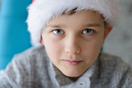 Close portrait of 8 years old boy in Santa Claus capの写真素材