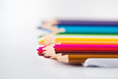 Coloured wooden pencils in row on white backgroundの写真素材