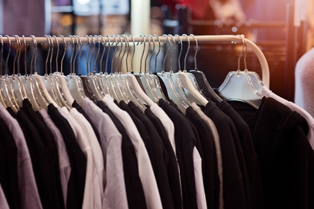 Shop hanger with new clothes in fashion store. December saleの写真素材