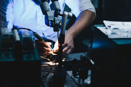 Man in his electrical workshop welding or soldering metalの写真素材