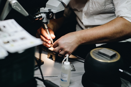 Man in his electrical workshop welding or soldering metal