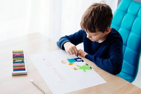 Happy 8 years boy child drawing a greeting card for his grandma for Grandma Day. Happy Grandmother Day!の写真素材