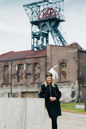 Woman black coal miner in gala uniform with white feathers on a mining hat. Working womanの写真素材