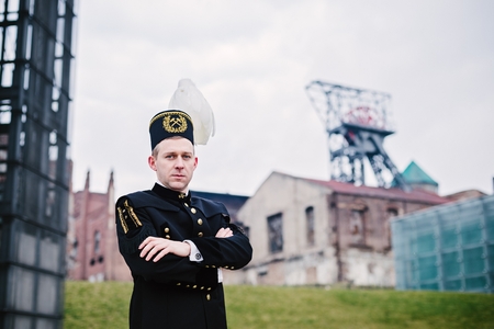 Man black coal miner in gala uniform with white feathers on a mining hat. Working manの写真素材