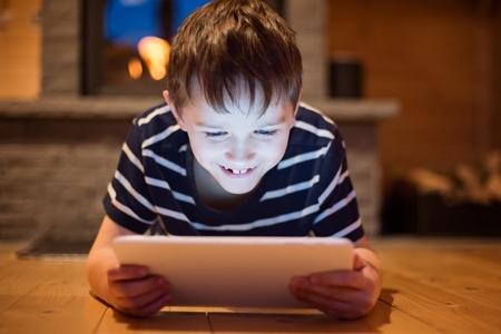 Eight years old boy using digital tablet at home.の写真素材