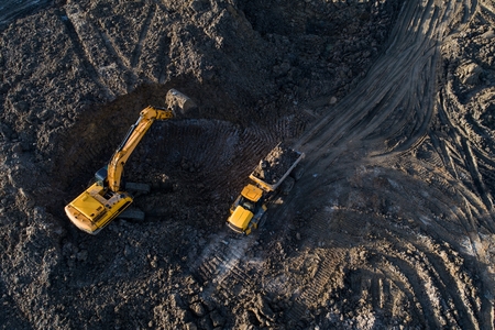 Aerial drone view of excavator loading the tipper truck at the construction siteの写真素材
