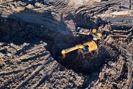 Aerial drone view of excavator loading the tipper truck at the construction siteの写真素材