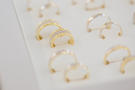 Silver and gold rings on the display in jewelry storeの写真素材