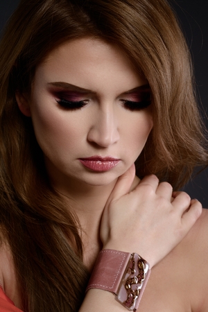 Studio beauty shot of woman with bracelet. Beautiful young woman posing with jewelry. Dark backgroundの写真素材