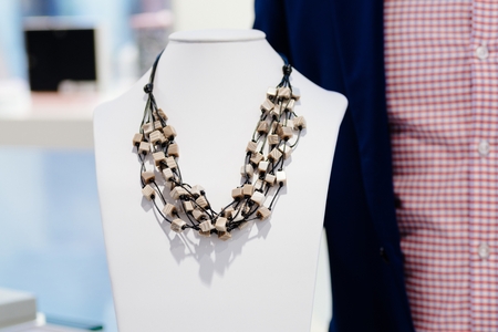 Polished stone necklace on neck stand display in a jewelry storeの写真素材