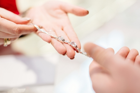 Female seller in a luxury jewelry store presents a bracelet. Buying a present. Jewelry store. Woman jewelerの写真素材