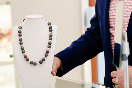 Agate stone luxury necklace on neck stand display in a jewelry storeの写真素材