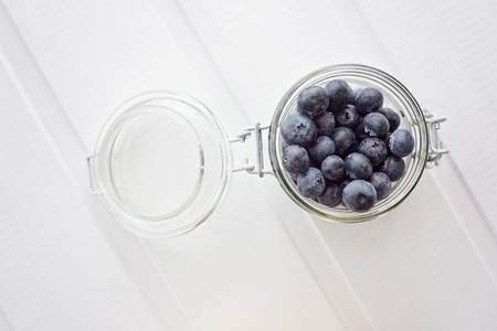 Delicious fresh blueberries in glass jar on tableの写真素材