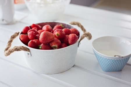 Delicious fresh red strawberries in metal bowl on tableの写真素材