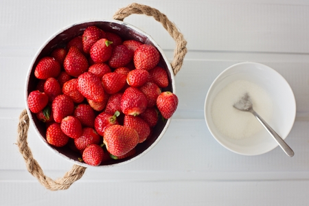 Delicious fresh red strawberries in metal bowl on tableの写真素材
