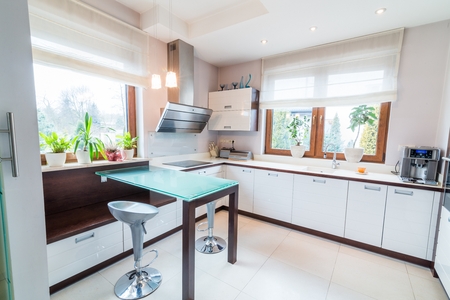 White modern kitchen with glass table and windowの写真素材