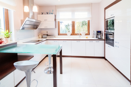 White modern kitchen with glass table and windowの写真素材