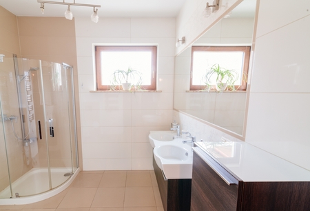 Modern bathroom with glass shower box and double washbasinの写真素材