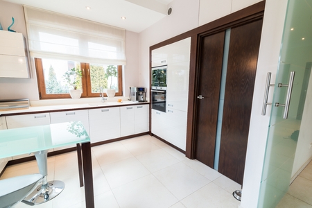 White modern kitchen with glass table and windowの写真素材