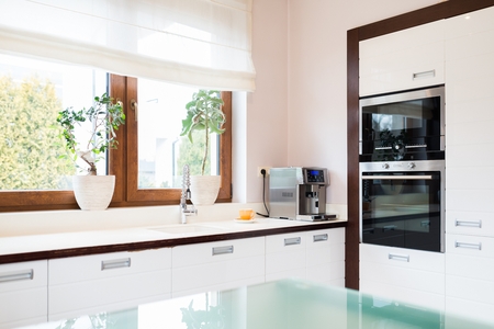Modern house kitchen with white wooden furnitures and windowの写真素材