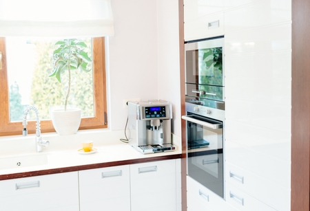 Modern house kitchen with white wooden furnitures and windowの写真素材