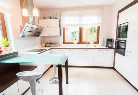 White modern kitchen with glass table and windowの写真素材
