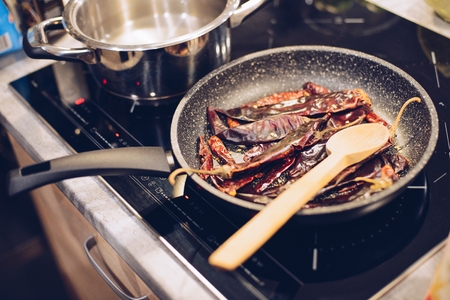 Frying hot smoked pepper on the frying panの写真素材